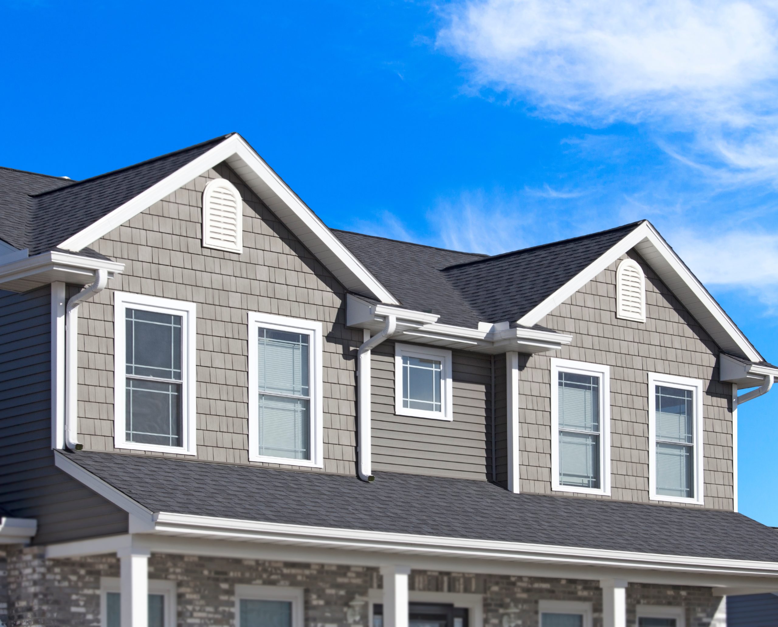 New home with grey siding Two-story home with gray siding, white trim, and dormer windows